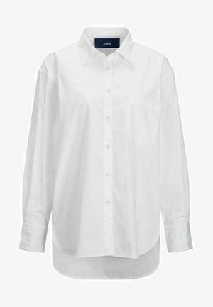 Hvid langærmet skjorte i glat bomuld med knapkrave, frontlomme og buet nederkant. Har en rygskulder for ekstra struktur.