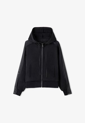 Czarna kurtka z kapturem z zamkiem z przodu, teksturowana tkanina na tułowiu oraz przezroczyste, wzorzyste panele wzdłuż rękawów.