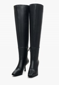 Czarne kozaki za kolano na szpilce z gładkiej skóry, z kwadratowym noskiem i zamkiem błyskawicznym z boku. Smukły design z dopasowaną sylwetką.