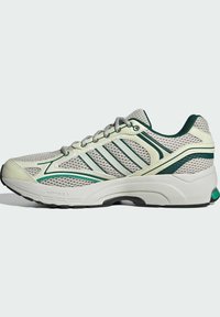 Mesh running shoe in light gray with green accents. Features a cushioned sole, structured design, and reflective stripes on the sides.