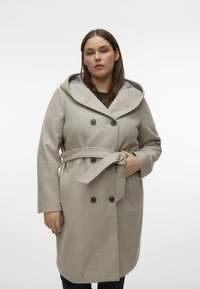 Lys grå uldfrakke med hætte, dobbeltradede knapper, et bælte med slipse og sidelommer. Blød tekstur, elegant design og skræddersyet pasform.