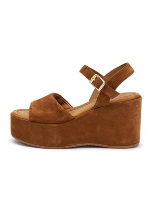 Sandalo con zeppa in camoscio marrone, punta aperta, cinturino regolabile alla caviglia e fibbia dorata su una suola spessa con piattaforma.