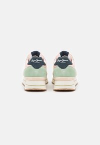 Schoenen met een bovenwerk van roze en groene suede, witte tussenzool en een gumrubberen buitenzool; heeft een donkerblauwe hielaccent en logo.