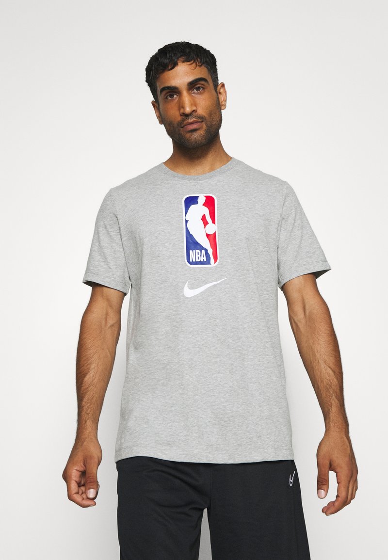 Grå bomulds T-shirt med et stort NBA-logo i rød, hvid og blå, samt en hvid Nike swoosh på forsiden. Korte ærmer, rund hals.