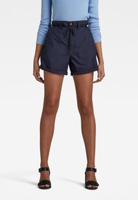 Námorně modré šortky s elastickým pasem a ohrnutými lemy; vyrobené z lehkého materiálu, s bočními kapsami a předním knoflíkovým detailem.