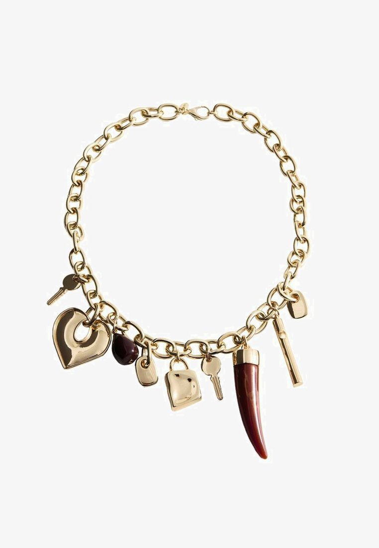 Bracelet chaîne en or avec des breloques comprenant des clés, des cœurs, une pierre sombre, une plaque en or et un pendentif en forme de corne rouge sur fond blanc.
