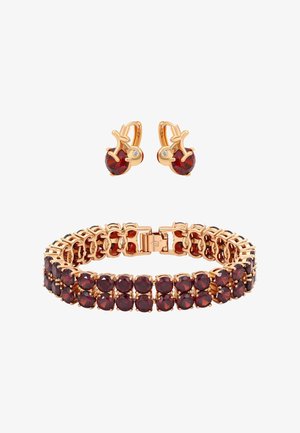 Arany karkötő és hozzáillő fülbevaló szett mélyvörös, kerek drágakövekkel és apró, áttetsző díszkövekkel, fehér háttér előtt.