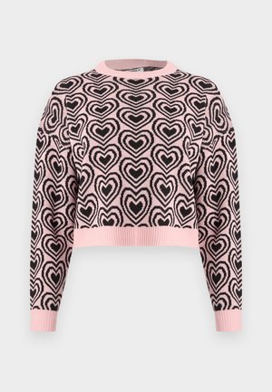 Roza skrajšan pulover z vzorcem črnih src, rebrastim okruglim izrezom in manšetami. Material se zdi mehak z teksturirano površino.