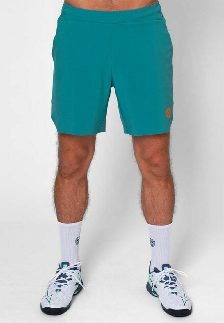 Pantalones cortos atléticos color teal con una textura suave, cinturilla elástica y detalles del logo en naranja. Combinados con calcetines blancos y zapatillas deportivas con estampado.