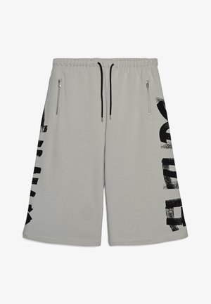 Pantaloncini grigio chiaro in tessuto morbido, con un disegno grafico nero sul lato sinistro e due tasche con zip sul davanti.