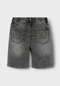 Shorts en denim gris avec une coupe décontractée, taille élastique, deux poches arrière et un délavage, présentant des surpiqûres contrastantes le long de l'ourlet.