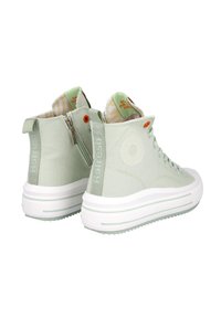 Zapatillas altas de color verde claro con material textil, suela de plataforma blanca, cremallera lateral y un acento naranja cerca de los cordones.