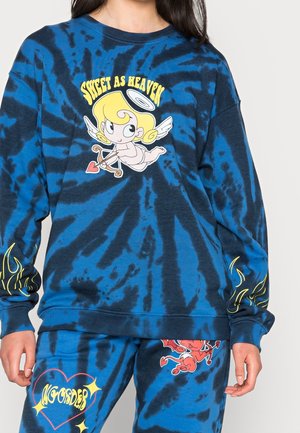Blå og sort tie-dye sweatshirt og bukser med tegneserieengel og djævledesign samt gule flammedesigns på ærmerne.