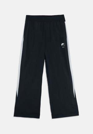 Schwarze Sporthose aus leichtem Material, mit weißen Seitenpaneelen, einem elastischen Bund und einem kleinen Logo am linken Oberschenkel.