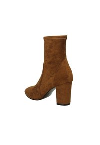 Stivale alla caviglia in suede marrone con tacco a blocco alto e punta appuntita. Texture liscia con dettaglio di cucitura.