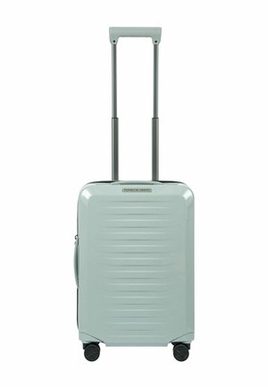 Valise cabine rigide de couleur bleu clair avec des rainures horizontales, poignée rétractable et roulettes noires pour une meilleure mobilité. Design léger et durable.