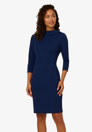 Gehäuftes, marineblaues Kleid mit Dreiviertelärmel und klassischem Kragen. Hergestellt aus elastischem Material mit dezenten Nahtdetails.