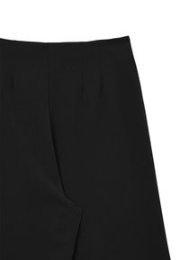 Pantalon noir ajusté au tissu lisse, ceinture structurée avec plis et poches latérales inclinées.