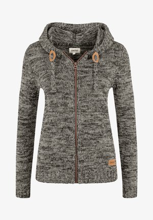 Pelēka un melna adīta kapuce ar rāvējslēdzēju, kurai ir koka toņa akcenti un liela kapuce. Auduma virsmā ir teksturēta raksts.