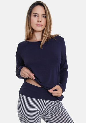 Marineblaues Langarmoberteil aus weichem Stoff, kombiniert mit gestreiften Leggings. Das Oberteil hat eine lässige Passform und einen weiter geschnittenen Halsausschnitt.