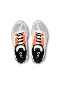 Baskets de sport blanches avec tige en mesh, accents orange vif, lacets noirs et logo circulaire sur la semelle intérieure. Design léger avec semelle rembourrée.