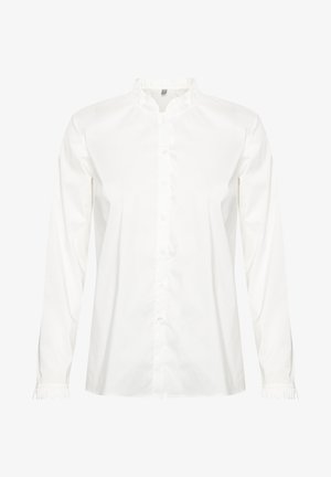 Balta garām piedurknēm pogājama krekla izgatavota no kokvilnas. Ar volānu apkakli un piedurknēm. Taisna griezuma ar gludu tekstūru.