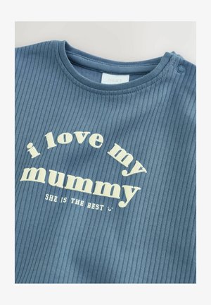 Plava pametna majica s kratkim rukavima i rebrastim uzorkom. Na sebi ima bijeli tekst: "volim svoju mamu" i "ONA JE NAJBOLJA" u zakrivljenom rasporedu.