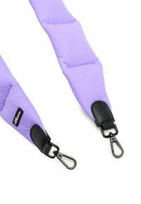 Sangle rembourrée lavande avec des accents en cuir noir et des clips en métal. Texture matelassée et logo en évidence sur un côté.