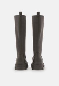 Botas hasta la rodilla en gris oscuro con un eje de tela elegante y suela de goma gruesa, con costuras verticales y lengüetas para facilitar su puesta.
