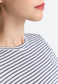 Gestreiftes Baumwoll-T-Shirt mit schmalen marineblauen und weißen Streifen, einem runden Halsausschnitt und einer weichen Textur mit einem leichten Schimmer.