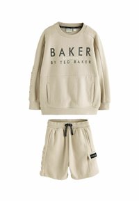 Sudadera de algodón beige con gráfico de "BAKER", mangas con puños y bolsillos frontales, combinada con pantalones cortos a juego que tienen bolsillos laterales y cordón.