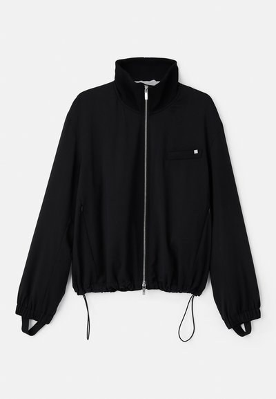 Black zip-up jacket with high collar, elastic cuffs, and a drawstring hem. Features a small front pocket and smooth fabric texture.