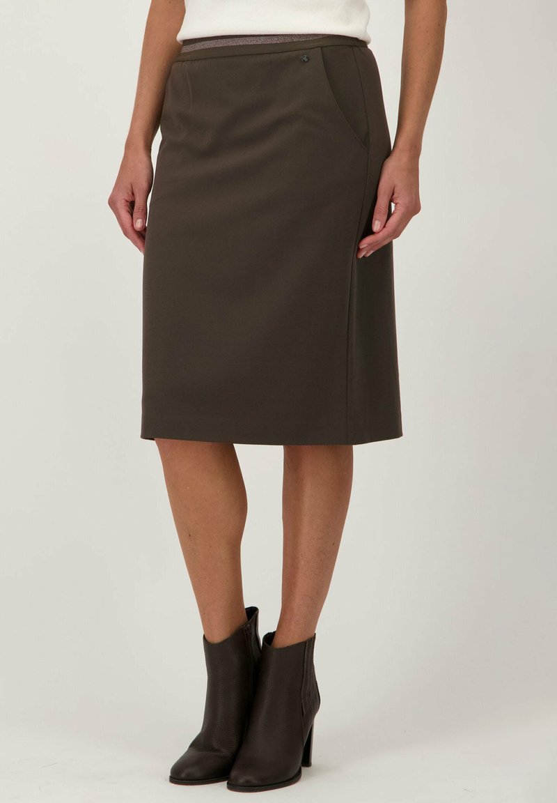 Jupe crayon marron longueur genoux en tissu extensible, dotée de poches latérales et d'une texture lisse, associée à des bottes marron hauteur cheville.