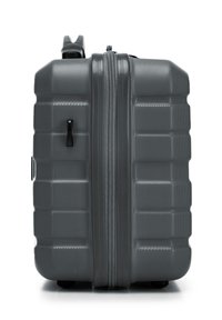 Grijze hard-shell koffer met een gestructureerd oppervlak, uitgerust met een dubbele rits, een handvat aan de bovenkant en vier zwarte wielen voor mobiliteit.