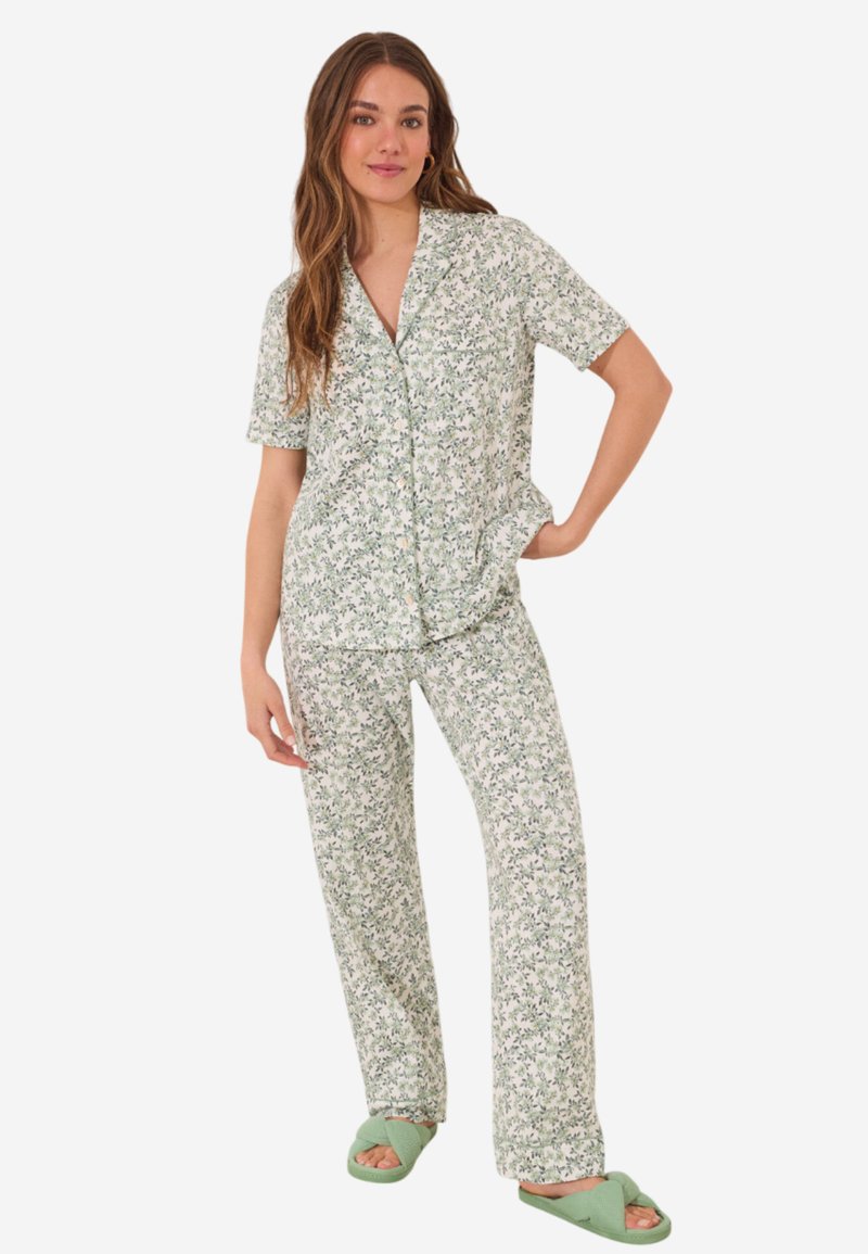 Pajamas à motifs floraux dans des tons de vert doux, comprenant un haut à boutons à manches courtes et un pantalon ample, associés à des chaussons verts.