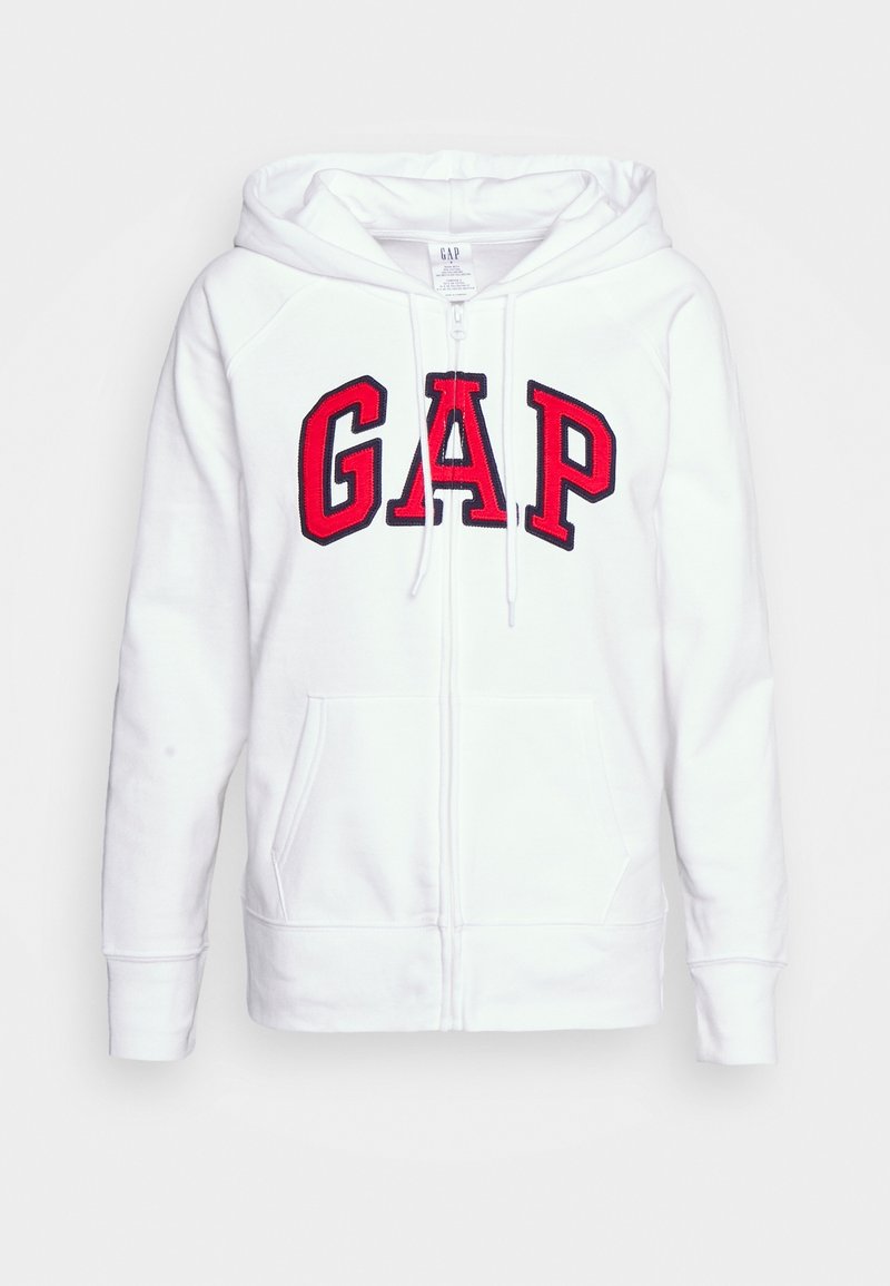 Sweat à capuche blanc zippé avec poches devant, logo GAP rouge en grandes lettres, et capuche avec cordons.
