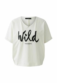 Weißes Baumwoll-T-Shirt mit V-Ausschnitt und kurzen Ärmeln. Mit schwarzem glitzerndem Text "Wild" und darunter kleiner "THOUGHTS". Weiche Textur.