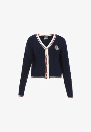 Marineblå kabelstrik cardigan med V-hals, cremefarvet og maroon stribet kant, guldknapper og et broderet våbenskjold på venstre bryst.