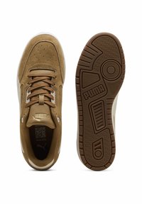 Baskets en daim beige avec accents blancs, bout rond, fermeture à lacets à l'avant, semelle en caoutchouc texturée et logo en relief sur la languette et la semelle.