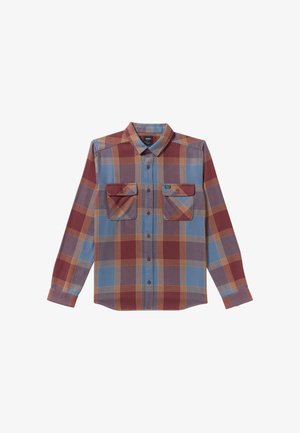 Ruudullinen nappi-yläliivi punaisena, sinisenä ja keltaisena. Ominaisuuksiin kuuluu kaksi rintataskua, pitkät hihat ja terävä kaulus. Puuvillaa tai sekoitemateriaalia.