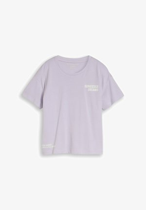 T-shirt violet clair à manches courtes avec col rond et texte blanc "SUNKISSED DREAMS" sur la poitrine et petit texte près de l'ourlet.
