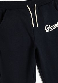 Dunkelblaue Jogginghose mit weißen Kordeln und "Colorado" in Weiß auf dem oberen rechten Oberschenkel gedruckt.