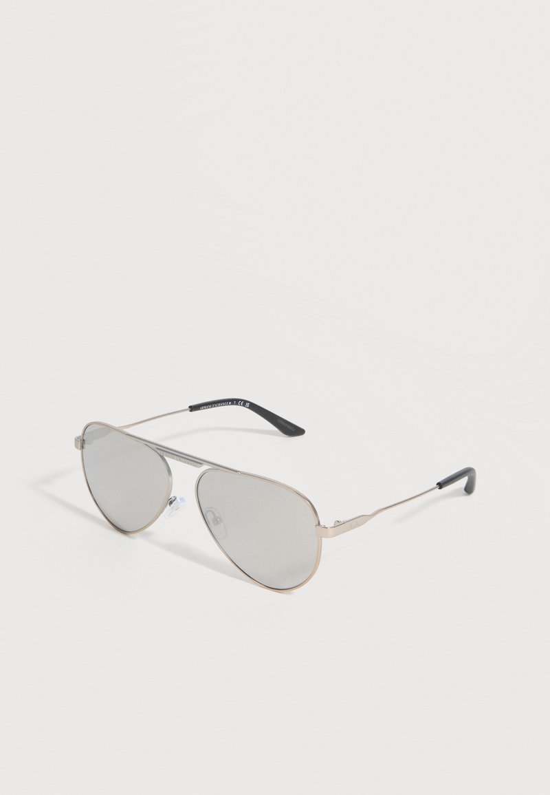 Γυαλιά ηλίου στιλ aviator με ασημένιους ανακλαστικούς φακούς και λεπτά ασημένια μεταλλικά πλαίσια με μαύρες πλαστικές άκρες στα μπράτσα.