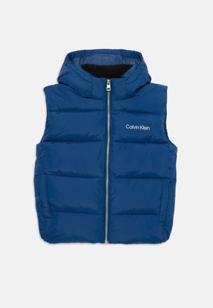 Gilet rembourré bleu avec capuche, fermeture éclair à l'avant, texture matelassée et logo « Calvin Klein » sur le côté gauche.