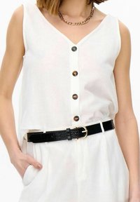 Valkoinen ilmanhiha, jossa on V-pääntie, esittelee nappilista sulkemista ja musta vyö kultaisella soljella. Kankaalla näyttää olevan kevyt ja sileä rakenne.