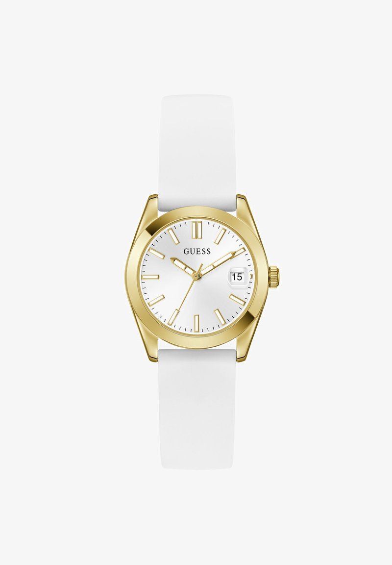 Montre ronde en or avec cadran blanc, index et aiguilles dorés, bracelet blanc, fenêtre de date affichant le 15, nom de la marque Guess sur le cadran.
