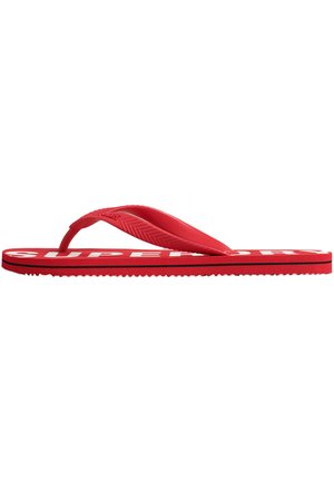 Red flip-flop sandal with black stripe on sole and white partial text on footbed, textured strap angled over toe post.