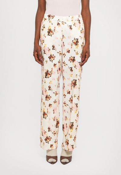 Un pantalon large en tissu léger présente un motif floral avec des accents roses, oranges et noirs, terminé par une taille lisse.