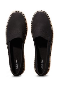 Scarpe slip-on nere in tela con suola in juta intrecciata e cuciture a contrasto. Presentano un logo impresso sulla parte superiore. Design classico e a profilo basso.