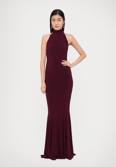 Bordo spalvos suknelė su kaklo raišteliais, aptemptu liemeniu ir platėjančiu apačia, pagaminta iš lygios, tamprios medžiagos. Be raštų ir matomų detalių.